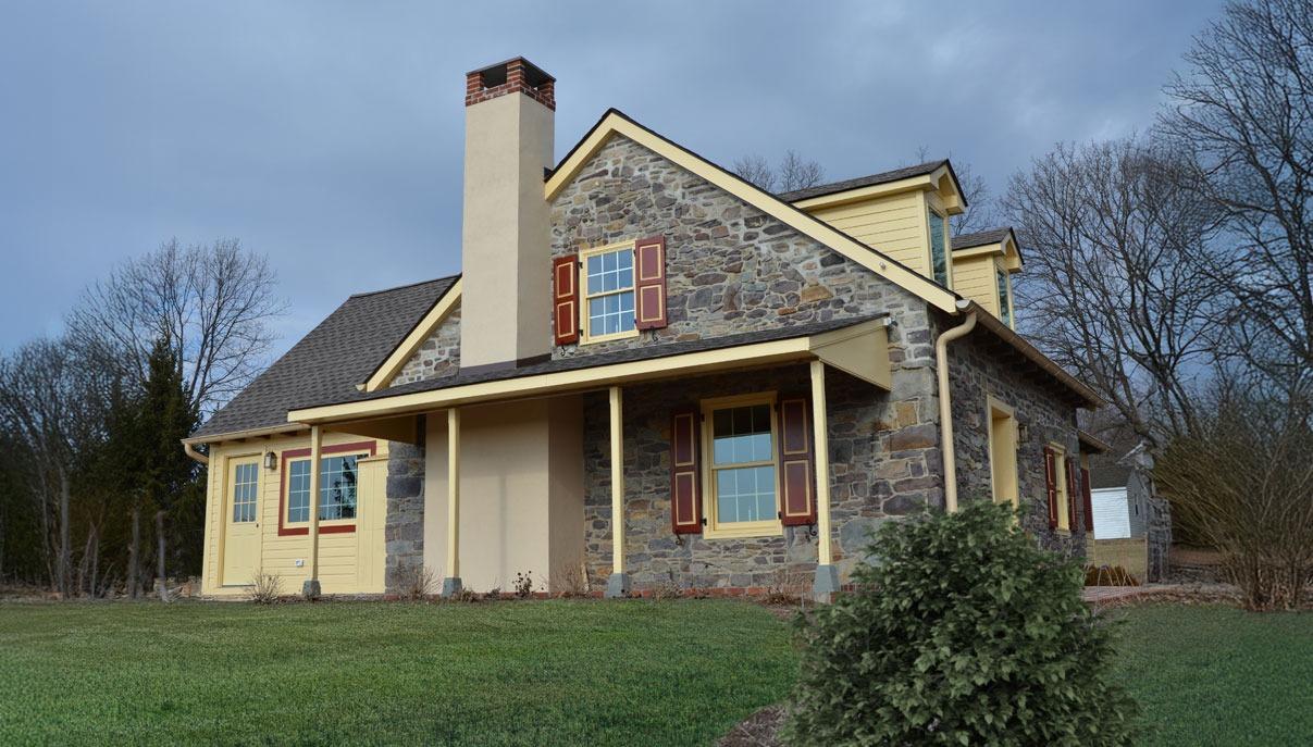The stone cottage with red shutters on the estate grounds